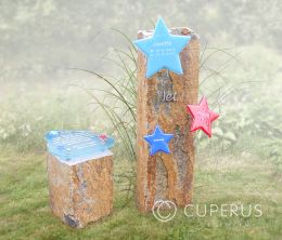 Kindergrafmonument met zuilen en gekleurde glazen sterren